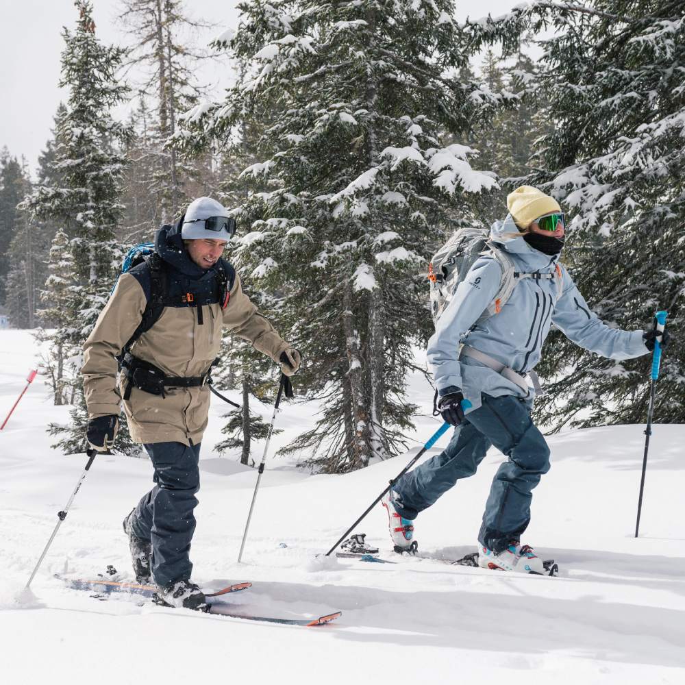 Zwei Ski-Touring Gänger unterwegs in einem verschneiten Wald