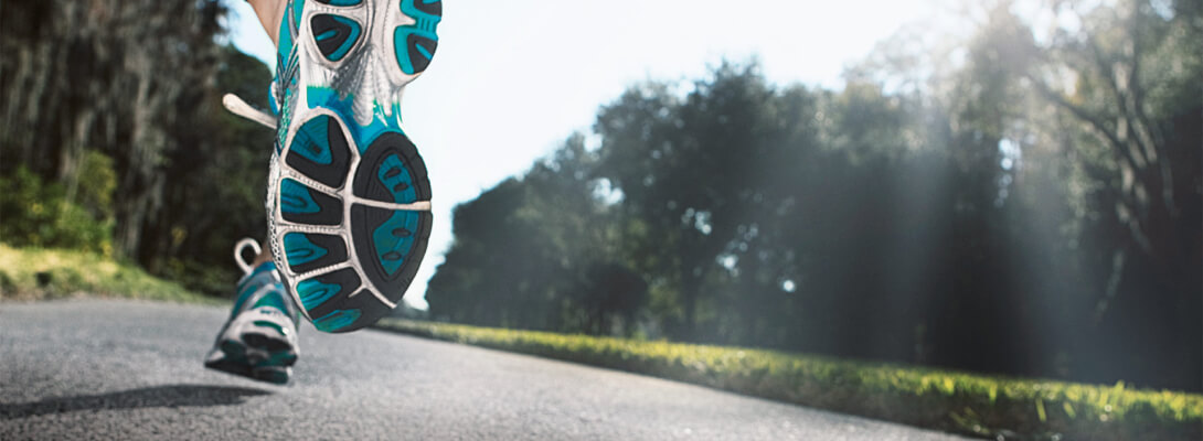 Laufen auf der Straße - Sportsocken Blick von einer Straße aus zeigt Laufschuhe von hinten