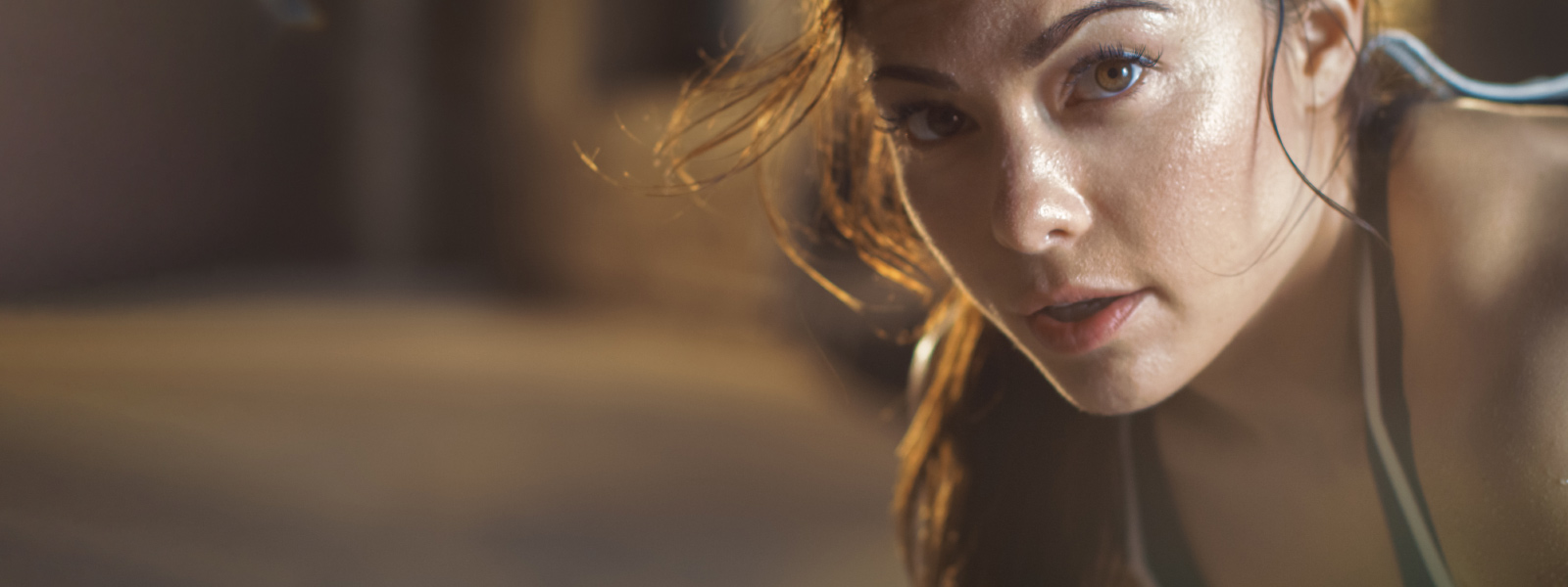 Schön ausgepowert dank Tabata-Workout Sportliche Frau sieht etwas verschwitzt von rechts den Betrachter an