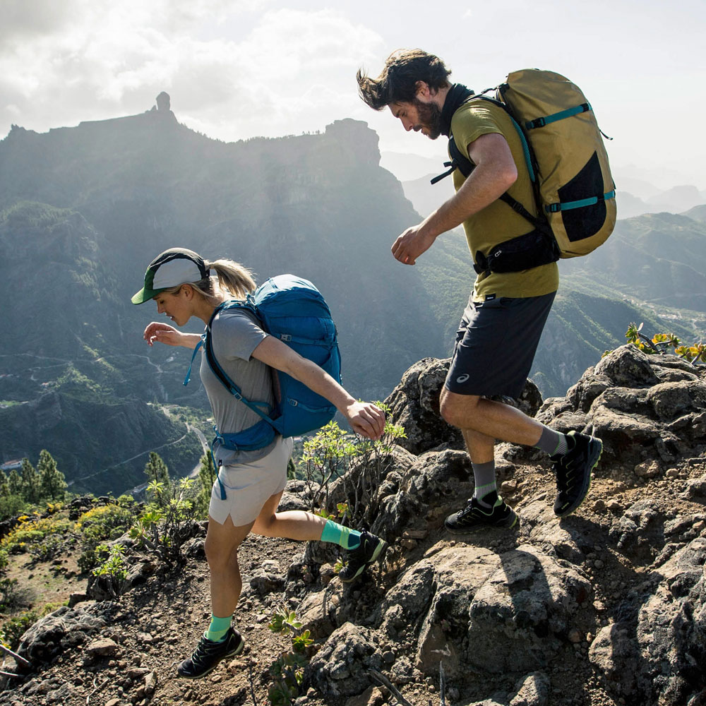 Wanderer die Trekkingsocken tragen	 laufen vor einem Bergpanorama den Berg hinunter