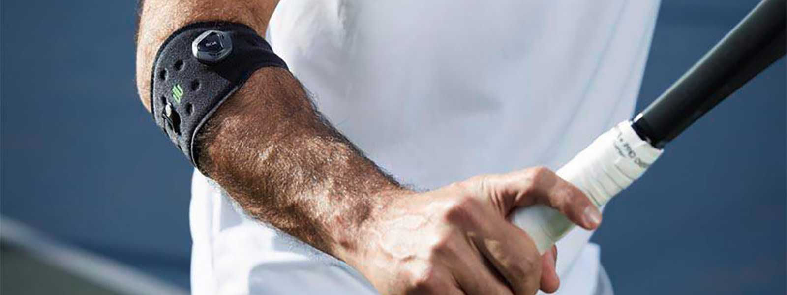 Die Sports Elbow Strap verhindert einen Tennisarm und unterstützt Dein Tennis-Spiel Tennisspieler mit Ellenbogenbandage hat Tennisschläger in der Hand