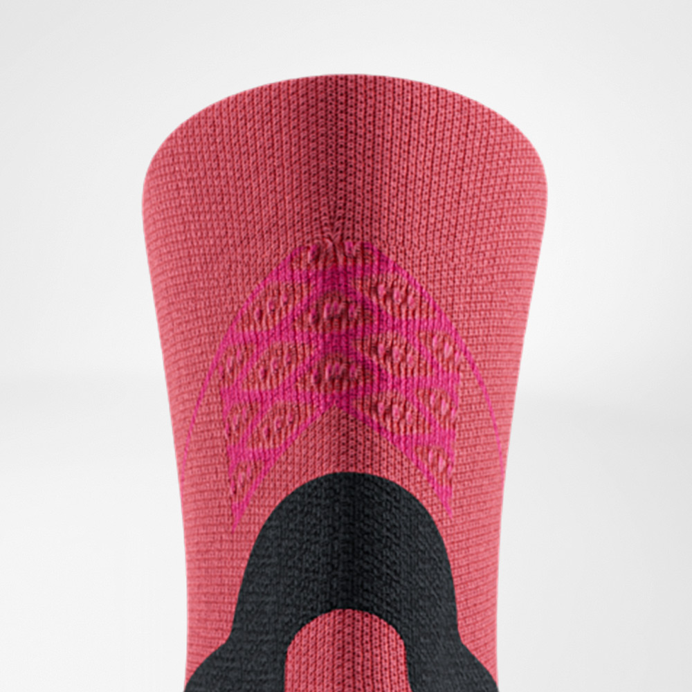Nahaufnahme der Run Performance Midcut Socks in Rot mit pinkfarbenen Akzenten am Schaft. Die Strickstruktur hebt die integrierten Funktionszonen hervor, die für Stabilität und Belüftung sorgen.