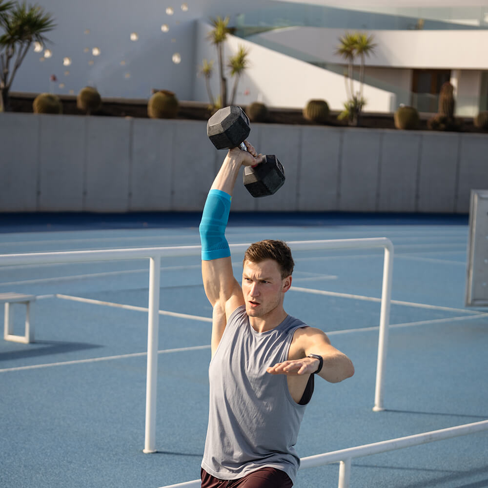 Mann trainiert mit Hantel und trägt einen Sportsleeve für den Ellenbogen