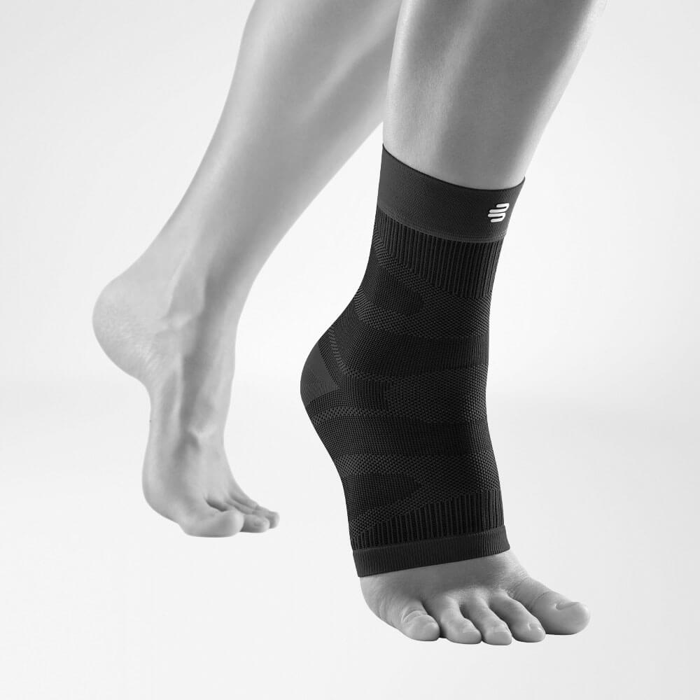Compression Ankle Support schwarz Vorderansicht schräg Komplettansicht der schwarzen Compression Ankle Support an einem stilisierten grauen Bein