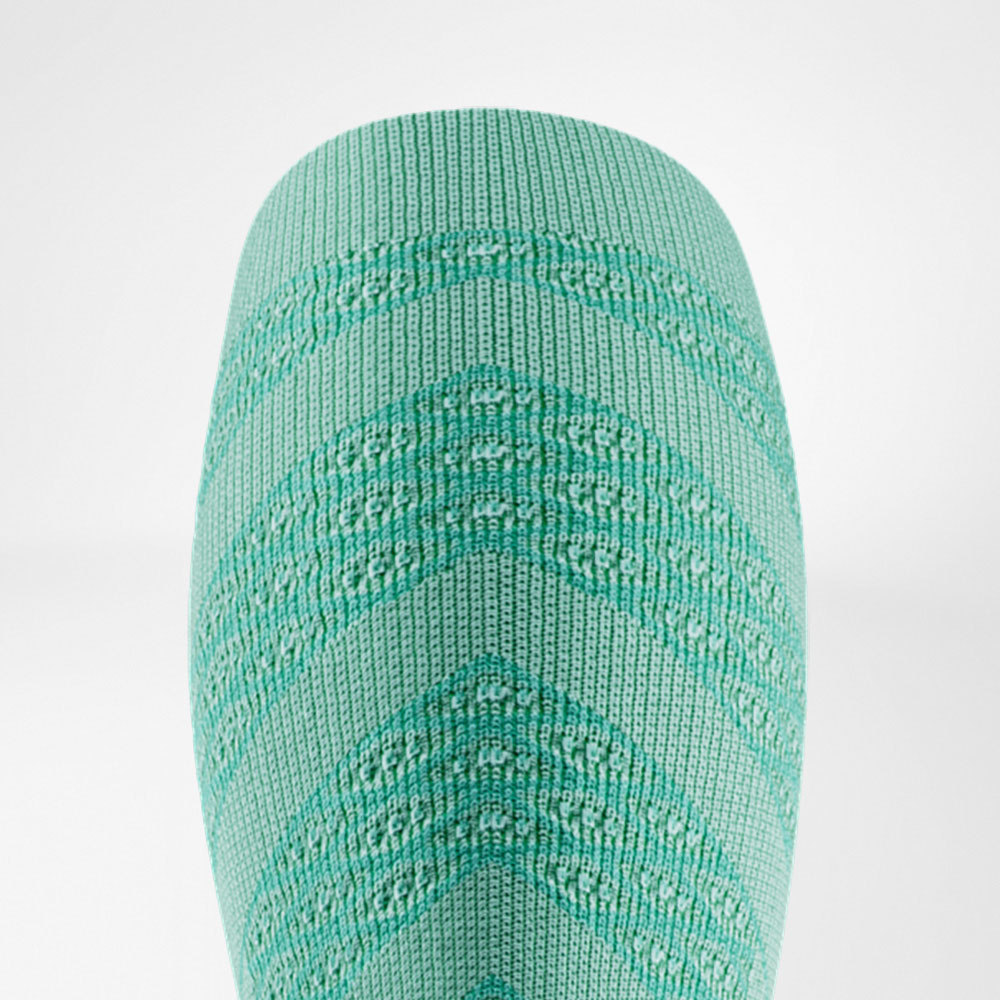Nahaufnahme eines hellgrünen Compression Sleeves mit feiner Strickstruktur in V-Form. Das Design wirkt frisch und leicht, ideal für sommerliche Läufe und lange Einheiten mit maximalem Komfort.