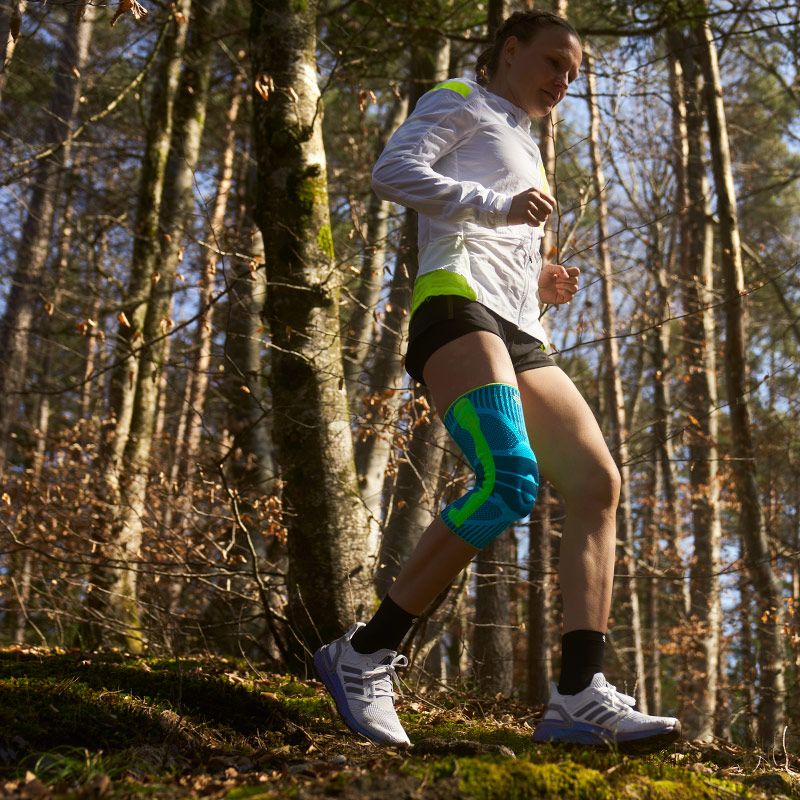Anna Hahner läuft mit einer Kniebandage den Waldweg herunter