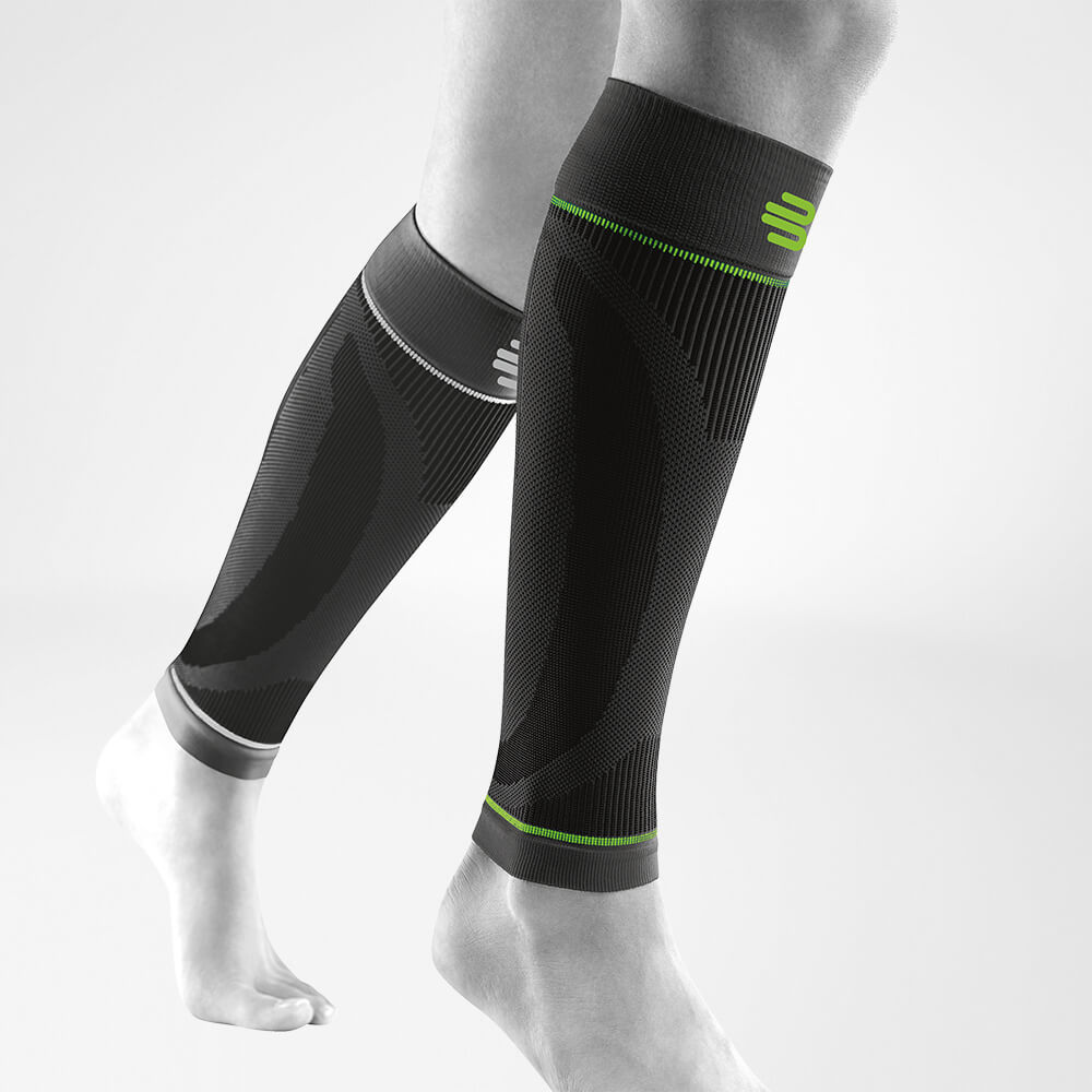 Waden Sleeves schwarz Vorderseite schräg Komplettansicht der schwarzen Unterschenkel Sport Sleeves am stilisierten grauen Bein