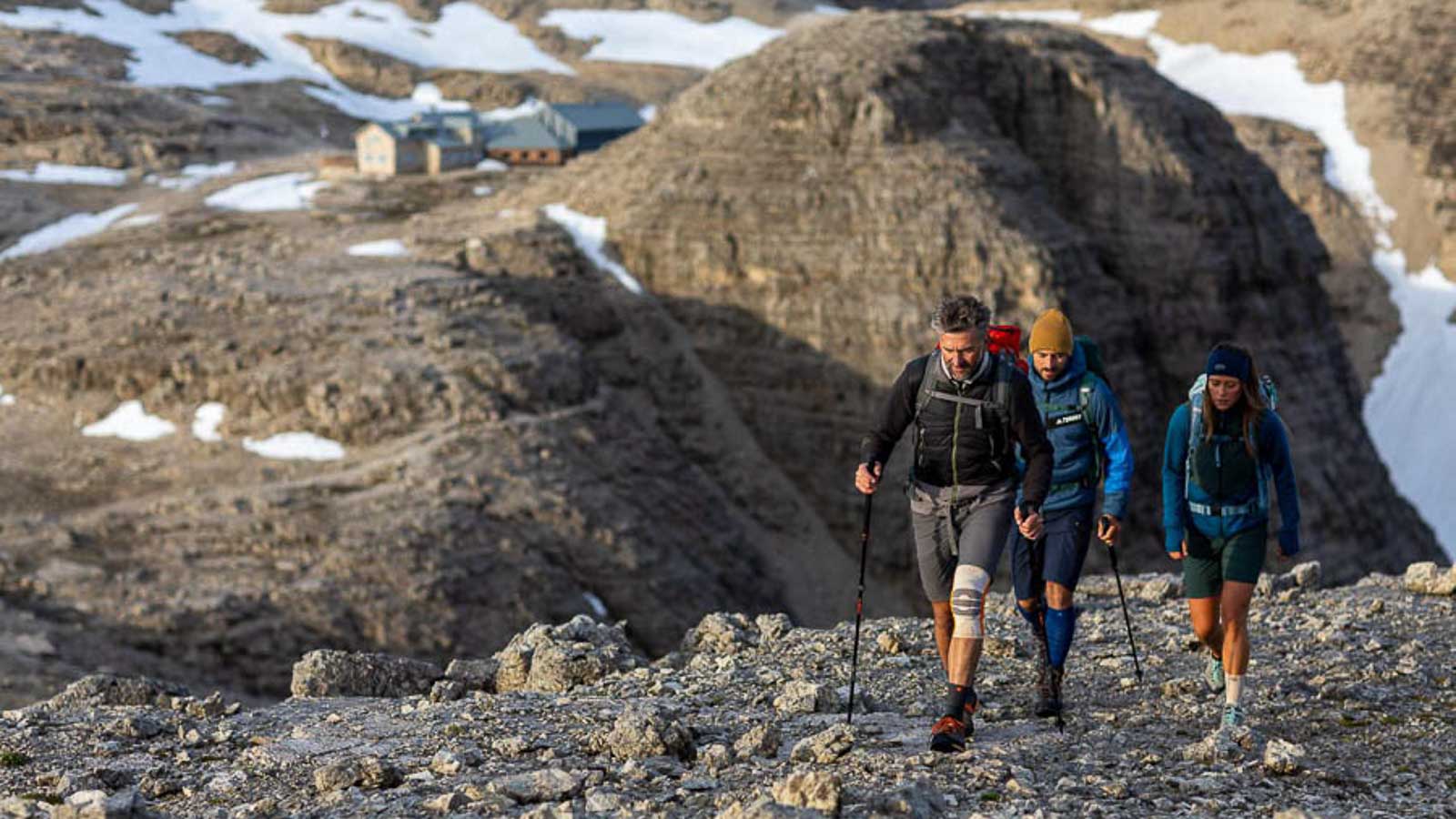 Schöne Wanderung in den Dolomiten Felsenlandschaft in den Dolomiten, im Vordergrund eine Wandergruppe mit Wander Bandage und Wander Socken, im Hintergrund ein Wanderhütte