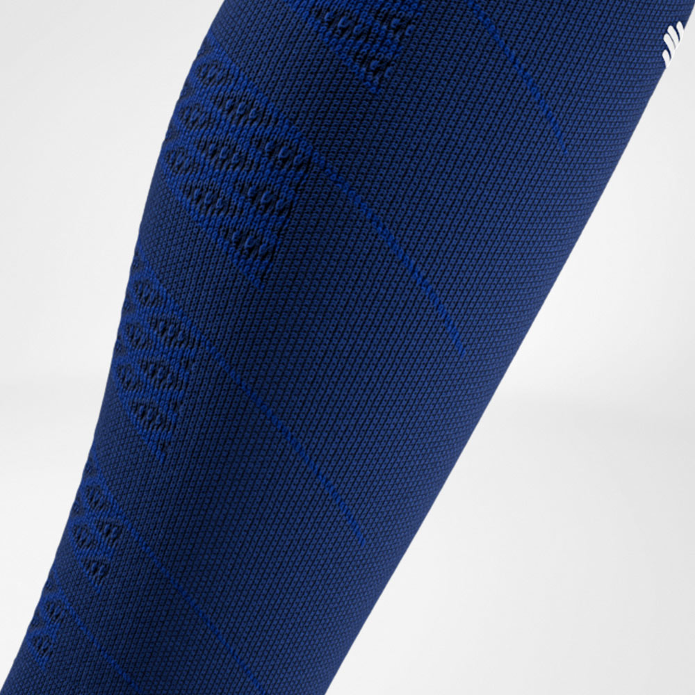 Detailaufnahme eines navyblauen Compression Sleeves mit feiner Textur und eingestrickten Kompressionszonen an der Wade.