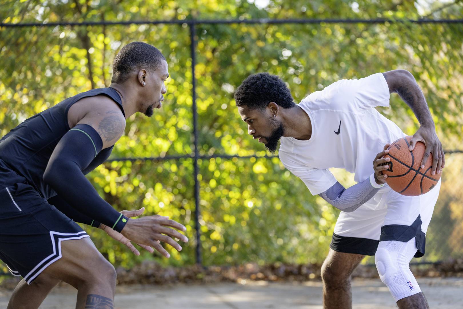 Streetballspieler in weißer Spielkleidung versucht seinen Gegner in schwarzer Spielkleidung auszuspielen