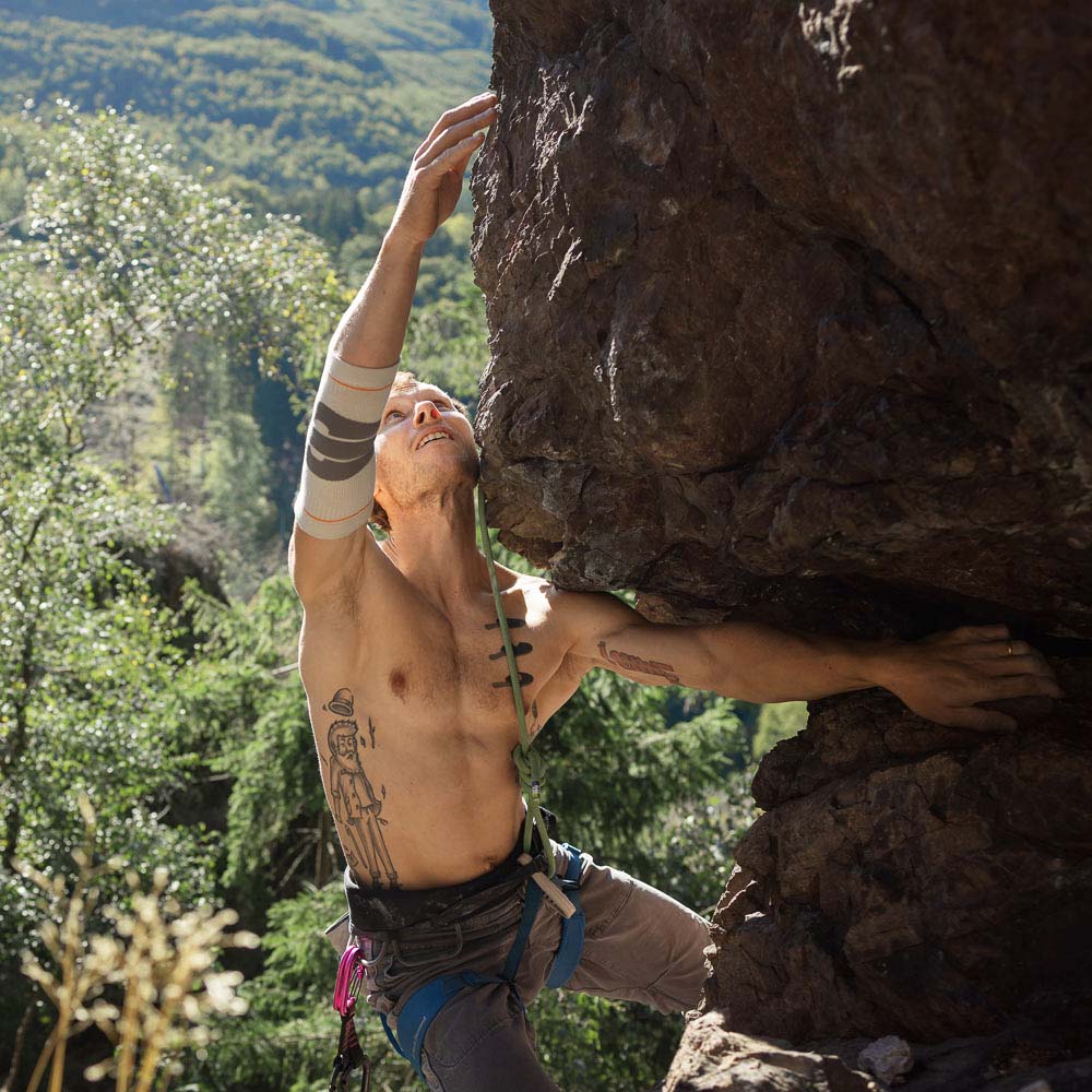 Ein Mann klettert einen Felsen nach oben.