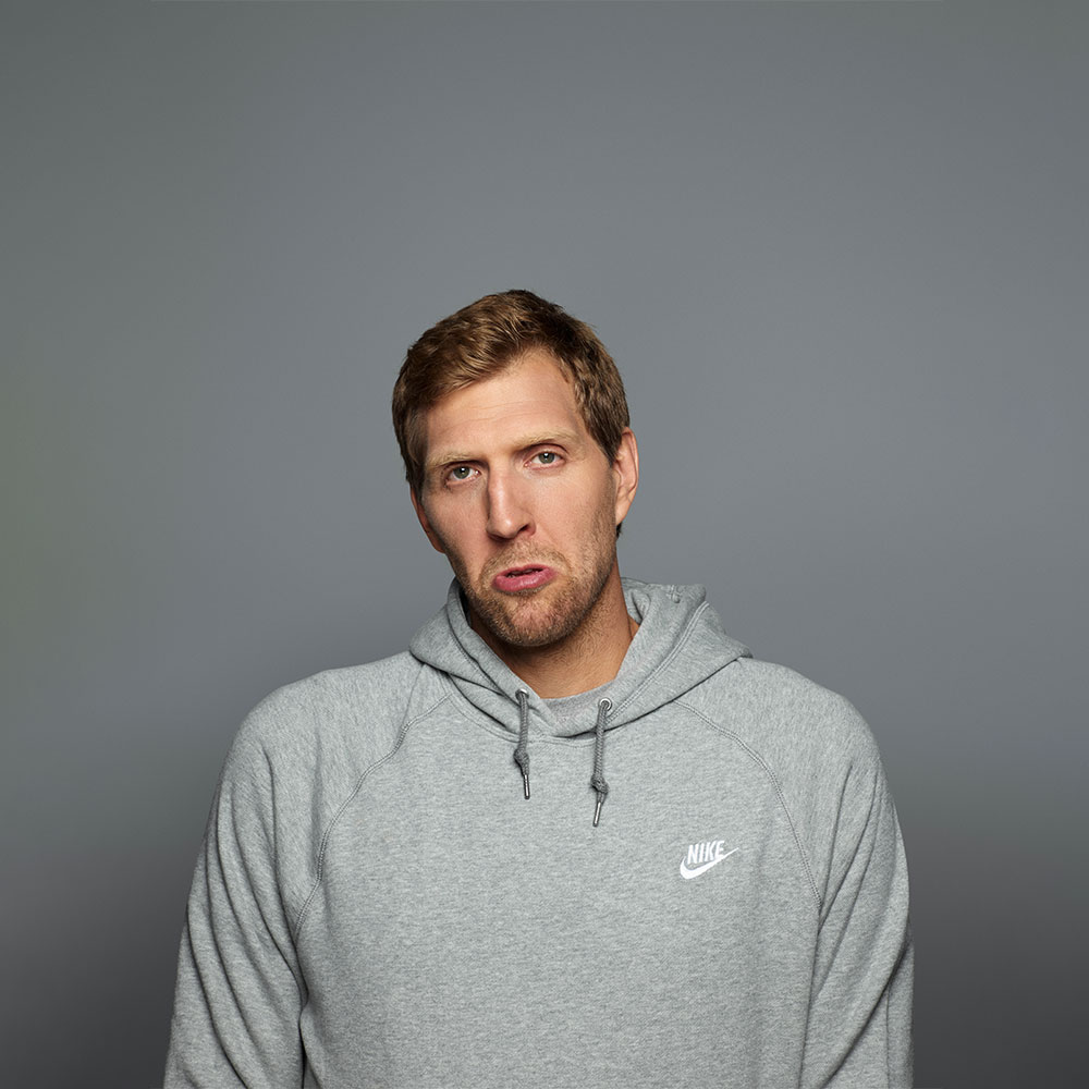 Dirk Nowitzki ist für (fast) jeden Spaß zu haben :) Dirk Nowitzki im grauen Hoodie vor grauem Hintergrund macht eine Grimasse