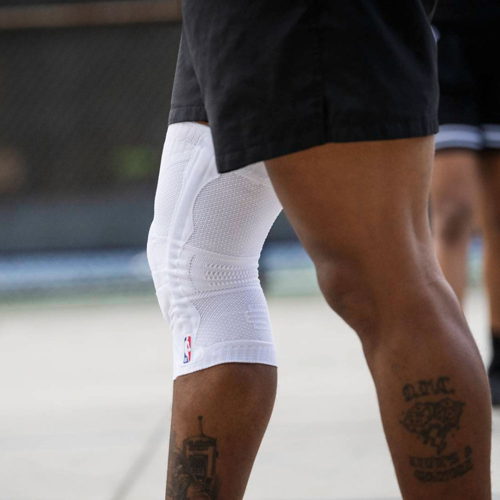 Bein eines Basketballspielers der Kniebandage trägt Ausschnitt eines Basketballspielers mit einer weißen Kniebandage mit NBA Logo