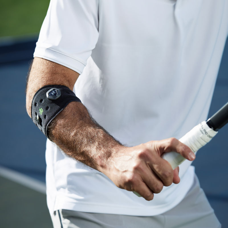 Unterarm eines Tennisspielers	 am Ellenbogen eine Bandage	 der den den Schläger in der Hand hält