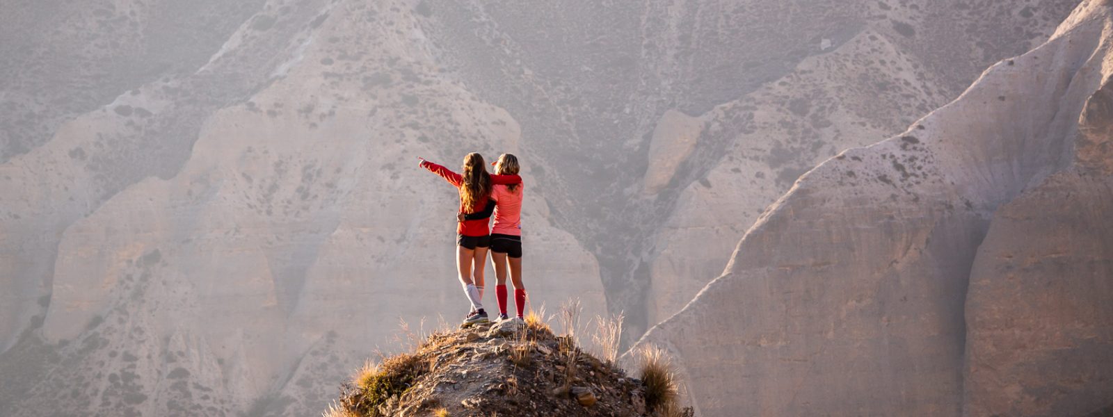 Kein Berg ist zu hoch für Deine Ziele - mit Leidenschaft und unseren Produkten Zwei Frauen jubeln auf einem Berggipfel
