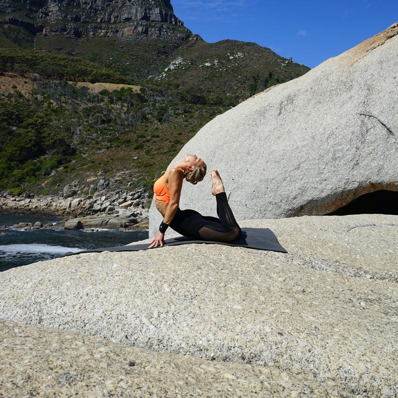 Outdoor Yoga - Sports Wrist Strap schwarz Frau in der Königskobra Pose im Hohlkreuz	 ihr Kopf berührt die Zehenspitzen