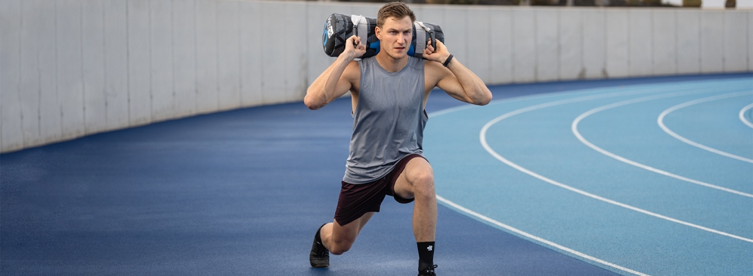 Training mit einer Sprunggelenkbandage Läufer mit Compression Ankle Support trainiert mit Hanteln