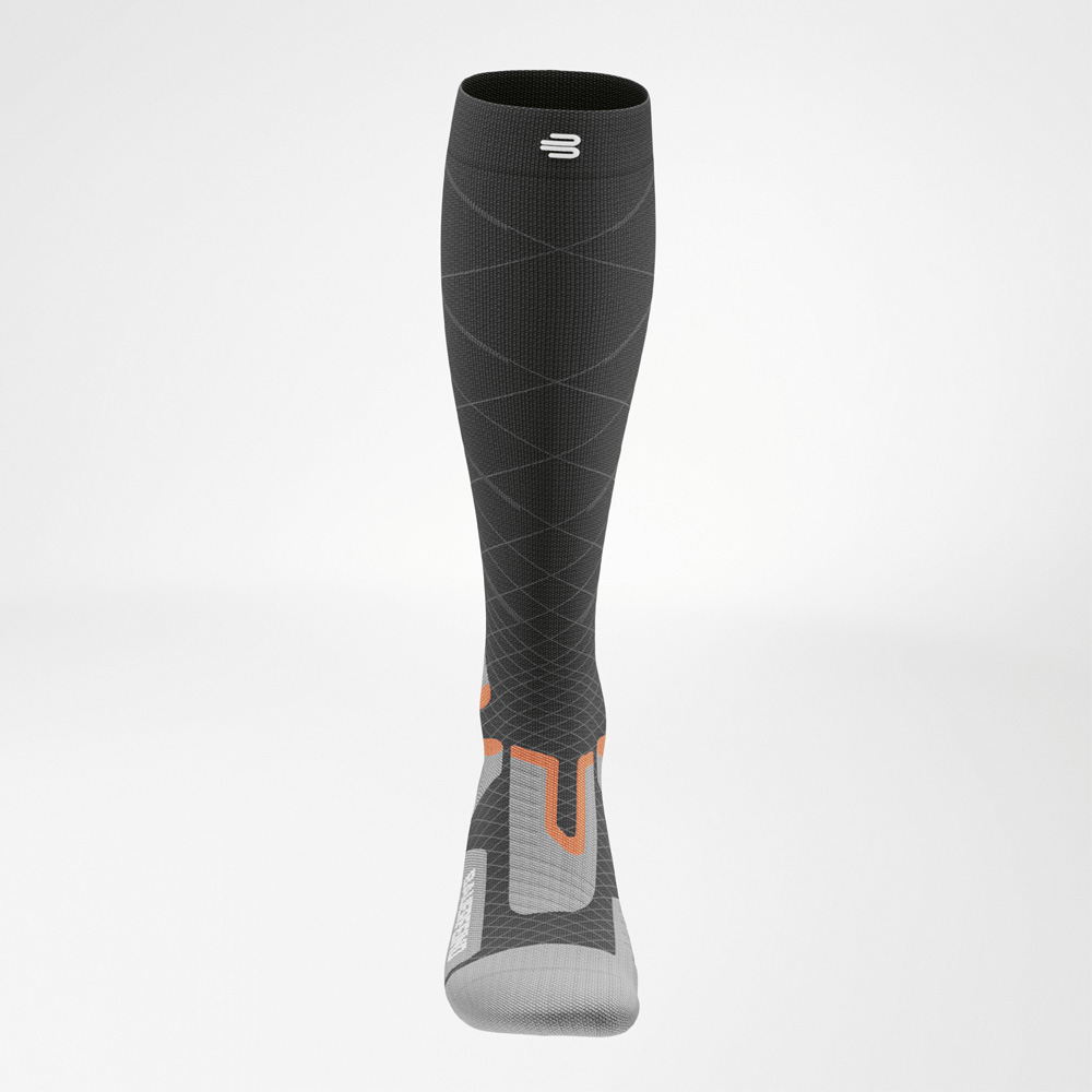 Höchste Kontrolle bei maximaler Geschwindigkeit Frontalansicht der Ski Performance Socke von Bauerfeind Sports. Die feinen Linien betonen die progressive Kompression am Schaft, das orangefarbene Muster signalisiert Stabilität und Führung.