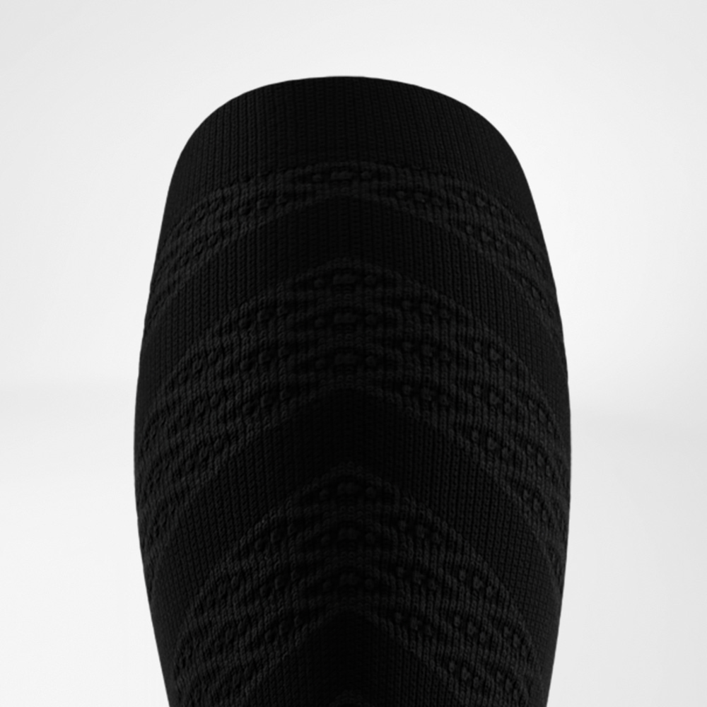 Obere Ansicht eines schwarzen Compression Sleeves mit markantem Zickzack-Strickmuster. Die Struktur bietet Stabilität und eine kraftvolle, sportliche Optik.