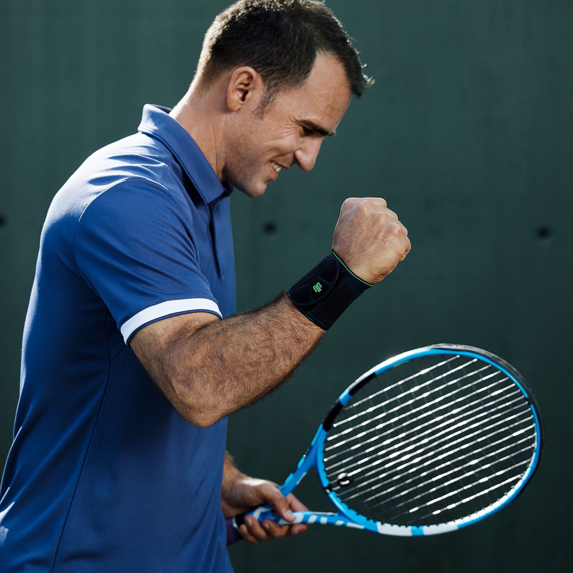 Handgelenkbandage schwarz beim Tennis Tennisspieler in Siegerpose mit Handgelenkbandage am rechten Handgelenk