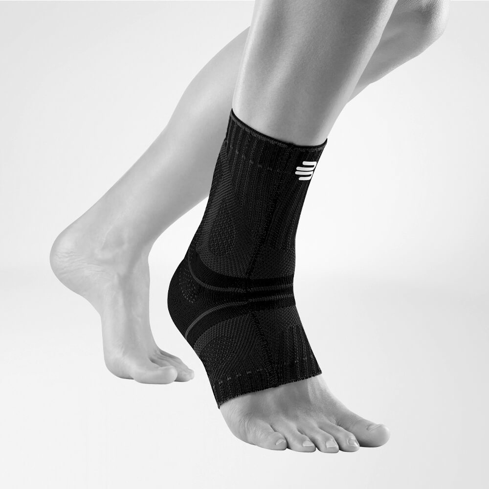 Achillessehnenbandage schwarz Vorderansicht schräg Seitliche Komplettansicht der schwarzen Achillessehnenbandage am stilisierten grauen Fuß