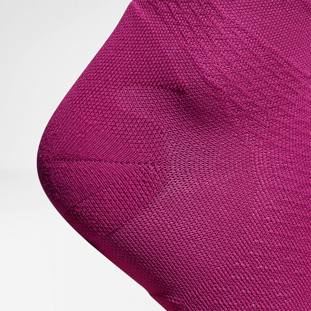 Detailansicht auf die Fersenschutzzone des rosafarbenen	 luftig gestrickten Kompressionsstsocksfes zum Laufen 