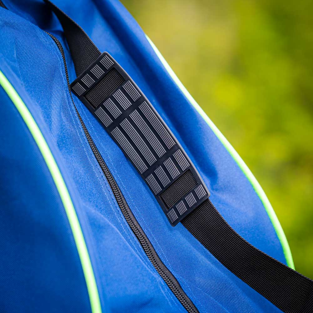 Gepolsterter Schulterriemen der Tasche Detailaufnahme eines gepolsterten schwarzen Schulterriemens an einer blauen Tasche mit grünen Akzenten. Der Riemen zeigt eine strukturierte Oberfläche für zusätzlichen Halt.