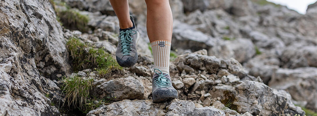Wander-Knöchelbandage beim Bergsteigen Nahaufnahme von Wander-Knöchelstütze auf felsigem Untergrund beim Bergsteigen.