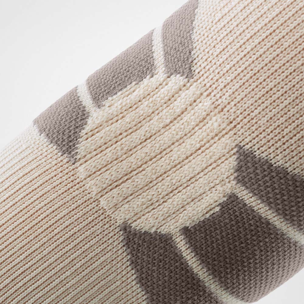 Detailaufnahme des Outdoor Compression Elbow Support in Sandstone. Die feine Strickstruktur und die integrierten Kompressionszonen sind deutlich erkennbar und zeigen die funktionale Materialkonstruktion für Stabilität