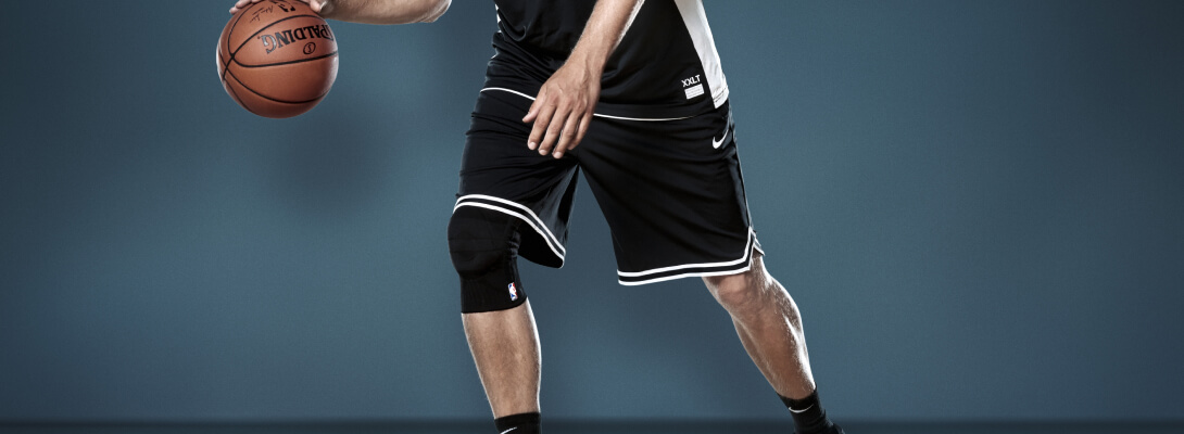 Basketballer beim Dribbeln trägt eine Sports Knee Support Dirk Nowitzki Edition