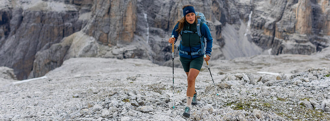 Abenteuerliche Bergwanderung mit der Wander Knöchelbandage Frau beim Bergwandern auf felsigem Gelände in den Alpen die eine Wander Knöcheöbandage trägt