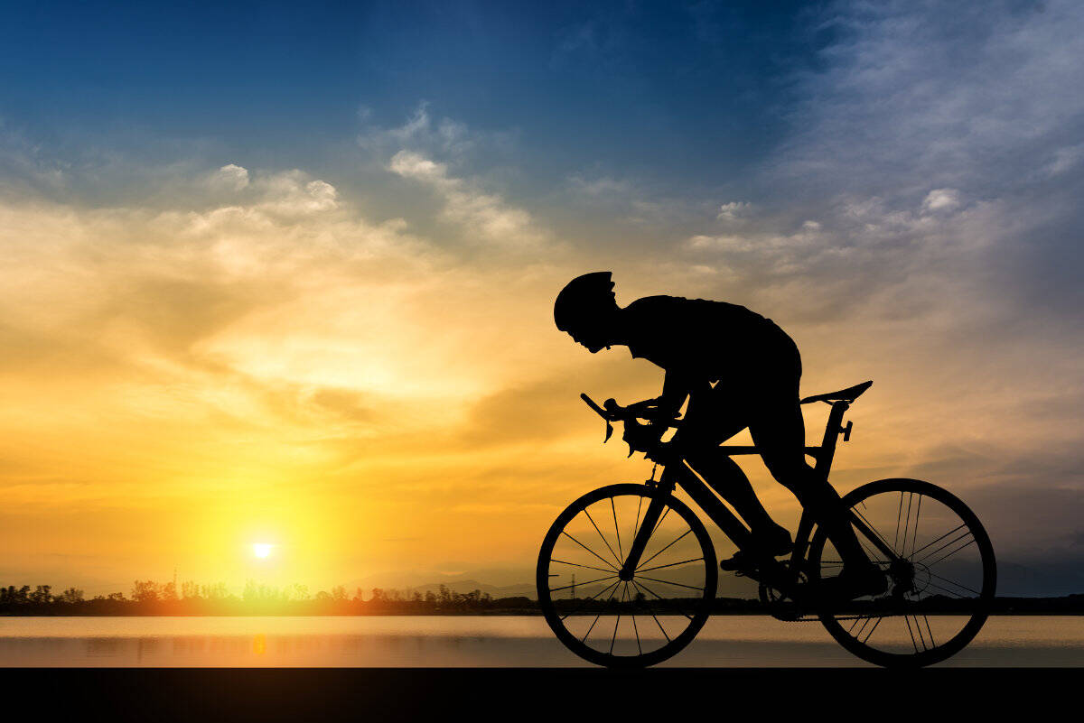 Silhouette eines Radfahrers im Schatten bei Sonnenuntergang