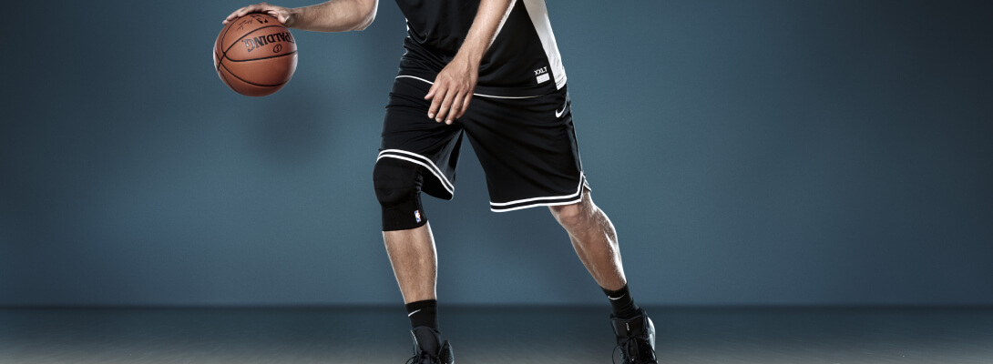 Basketballer beim Dribbeln trägt eine Sports Knee Support NBA
