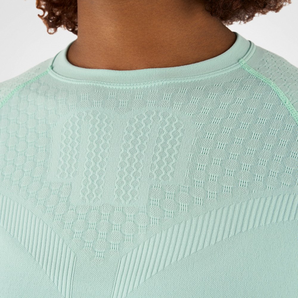 Nahaufnahme eines mintgrünen Kompressionsshirts mit strukturiertem Gewebe, das die Textur und Details des Materials zeigt.