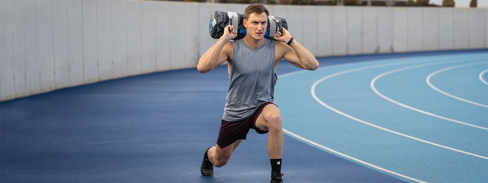 Thomas Röhler macht auf einer Laufbahn Squats mit einem Gewicht auf dem Rücken und einer Sprunggelenkbandage am Fuß