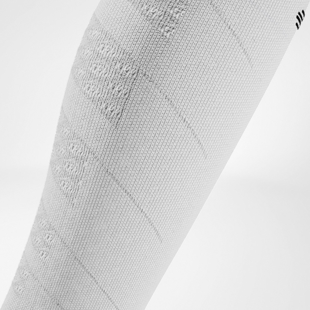 Detailaufnahme eines weißen Compression Sleeves mit markanter Strickstruktur. Das Material bietet eine klare, sportliche Optik und gezielte Unterstützung für die Waden.