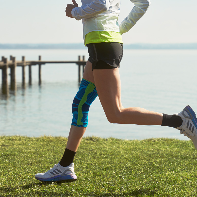 Anna Hahner läuft am See mit einer blauen Kniebandage