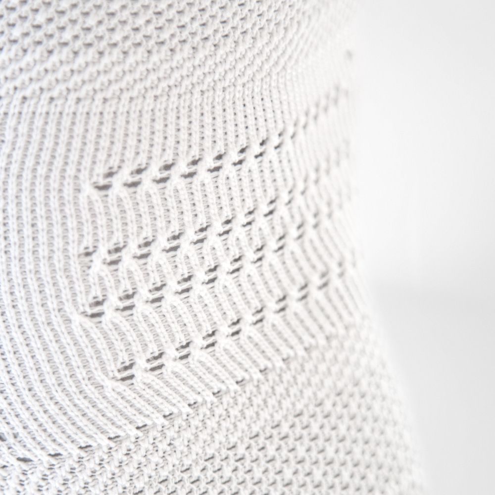 Detailansicht des atmungsaktiven Gestricks in der Kniekkehle der weißen Kniebandage für den Sport NBA Version