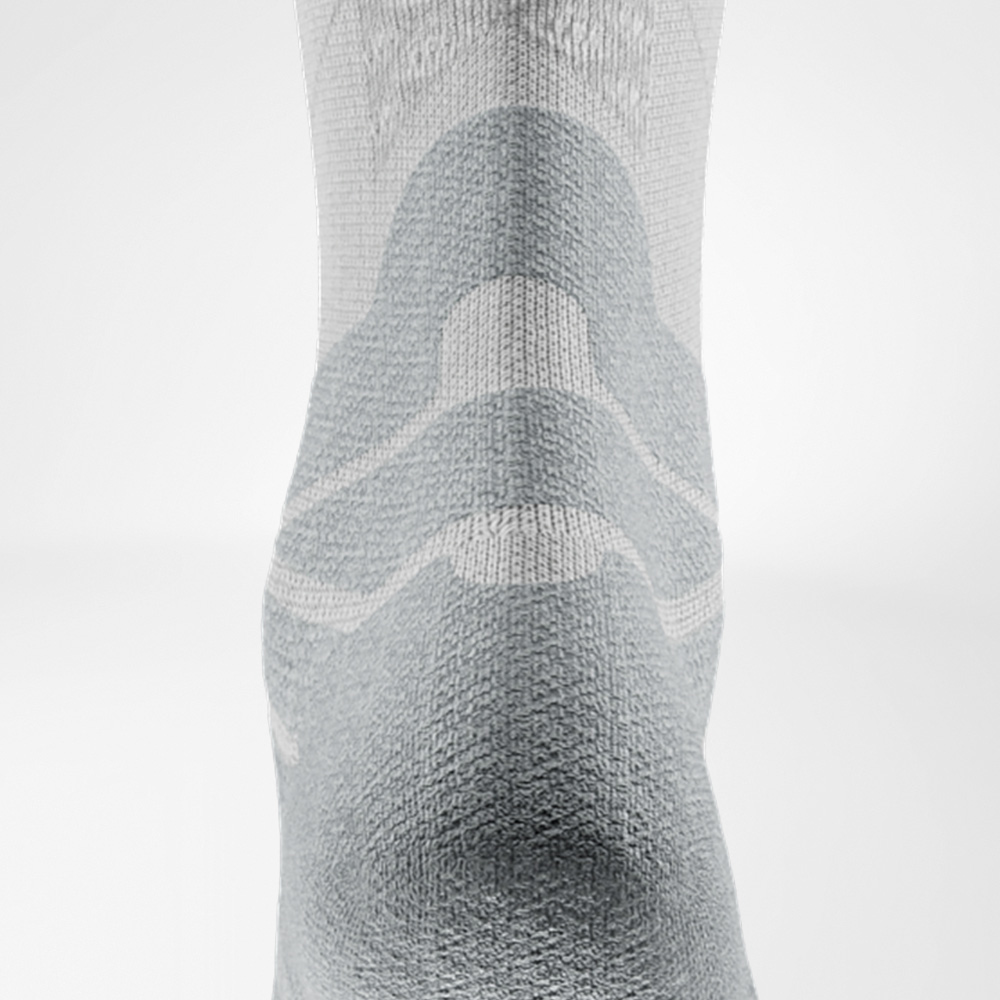 Detailaufnahme der weißen Run Performance Midcut Socke, Rückansicht mit betontem Strickmuster am Schaft und verstärktem Bereich über der Achillessehne.